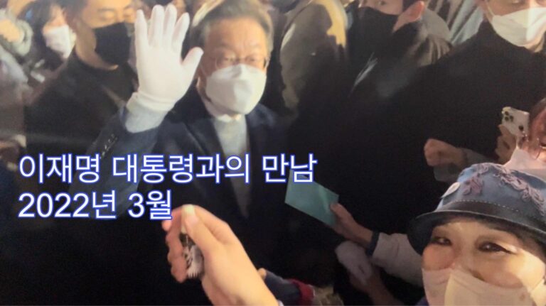 Moon Suk und Lee Jae-myung begegnen sich persönlich in einer Menschenmenge während des koreanischen Präsidentenwahlkampfs 2022, beide mit Masken.