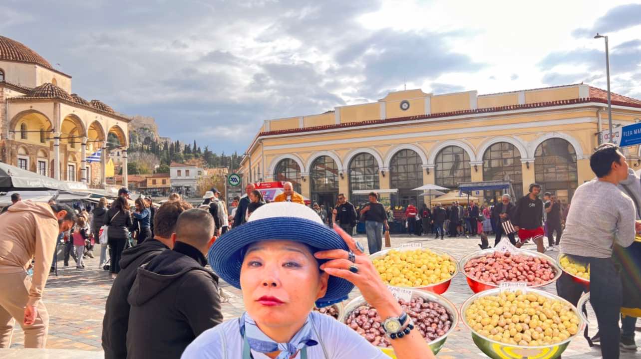 Frau mit Oliven in Athen am Monastiraki-Platz: Künstlerin Moon Suk im Gespräch mit dem Olivenverkäufer.