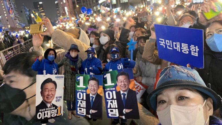 Präsidentenwahlkampf 2022 in Südkorea: Drei Plakate mit Lee Jae-Myung (이재명, Nr. 1) und Moon Suk unter den koreanischen Unterstützern in der Menge.