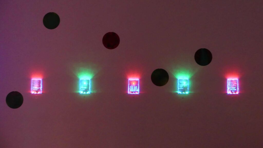 Fünf leuchtende Art-Boxen (drei rot, zwei grün) und fünf runde Gemälde als Kunstinstallation von Künstlerin Moon Suk.